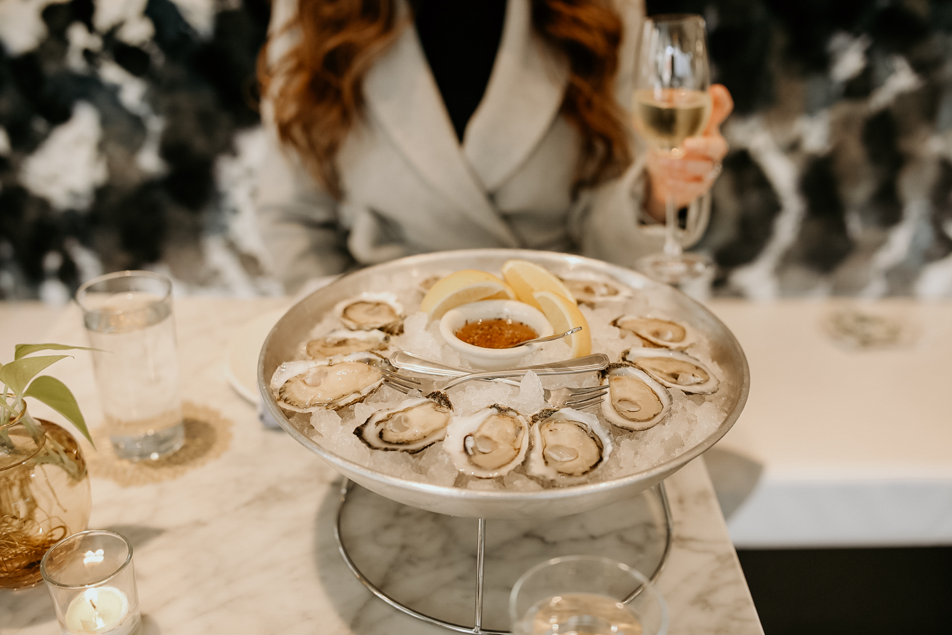 A guest enjoying champagne and a sampling from our raw oyster bar in Chattanooga.