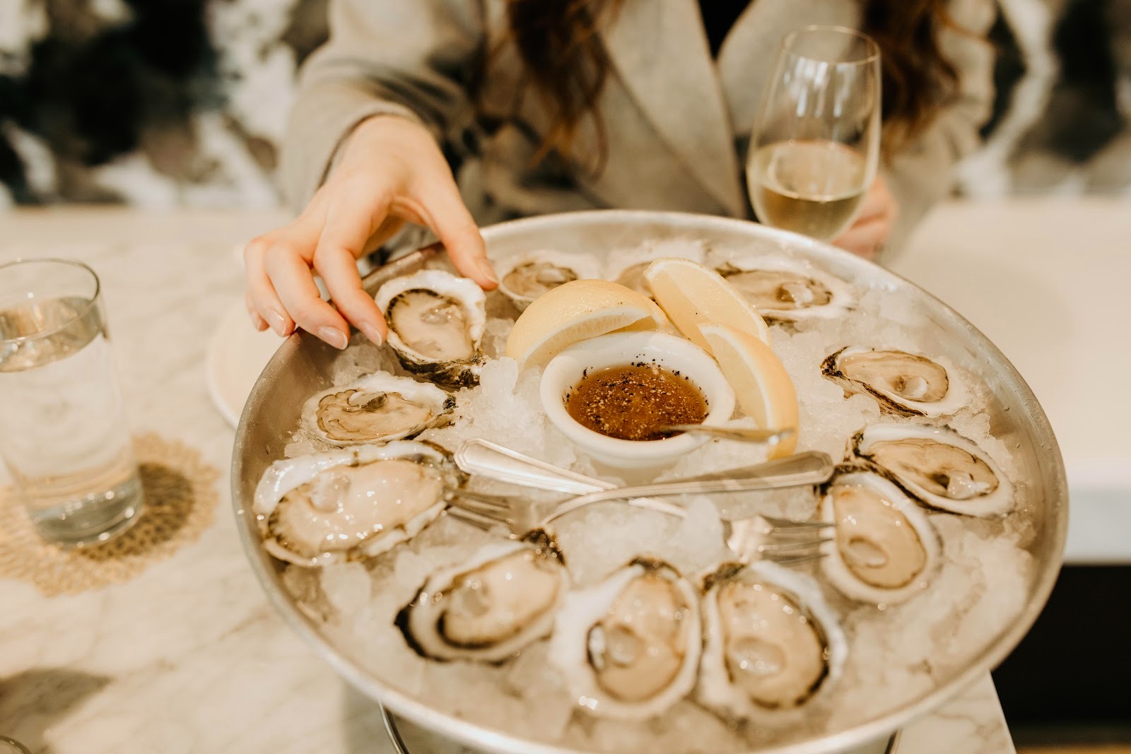 A person sampling oysters on a platter from the raw bar at Easy Bistro, one of the best places to eat in downtown Chattanooga.