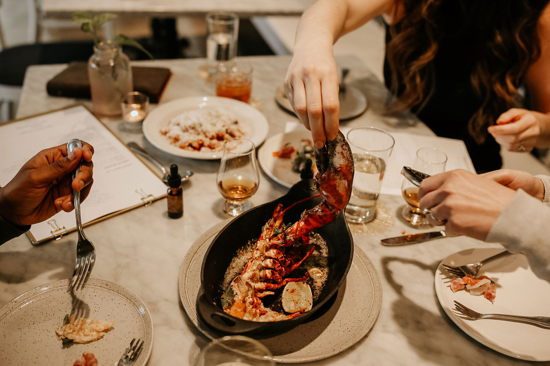 Three friends share a lobster dish